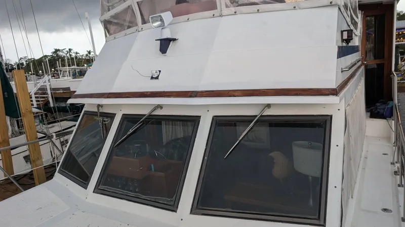 Slide: The Image of 1986 Heritage East 40 Sundeck boat docked, showcasing windows and deck details. - 6