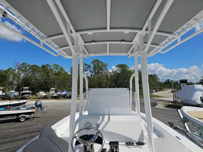 Slide: The Image of 2025 Savannah SS21 boat interior with steering wheel and canopy, parked outdoors. - 21