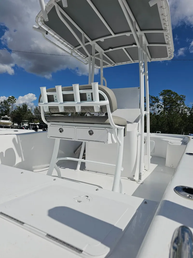 Slide: The Image of 2025 Savannah SS21 boat with T-top, white seating, and storage, under a clear blue sky. - 9