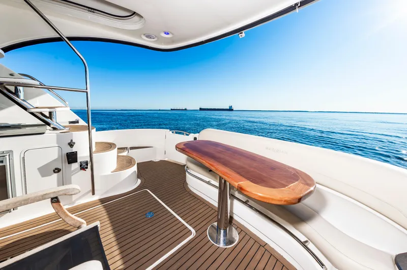 Slide: The Image of Luxurious 2011 Meridian 541 Sedan yacht deck with ocean view and elegant wooden table. - 14