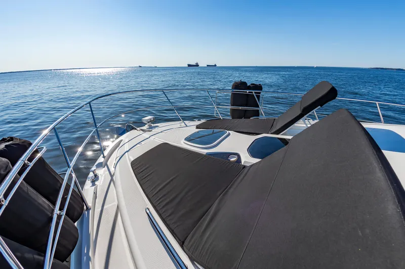 Slide: The Image of 2011 Meridian 541 Sedan yacht with sun loungers on deck, overlooking calm ocean waters. - 18