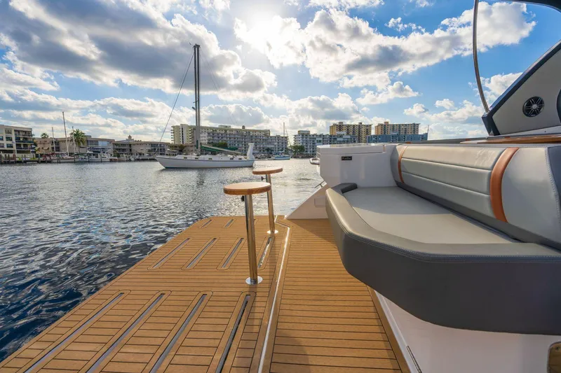 Slide: The Image of 2025 Hanover 377 Outboard boat with luxurious seating, docked in a scenic marina. - 11