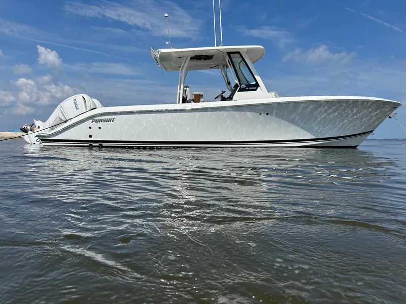 The Image of 2023 Pursuit S 288 Sport boat on calm water under a clear blue sky. - 0