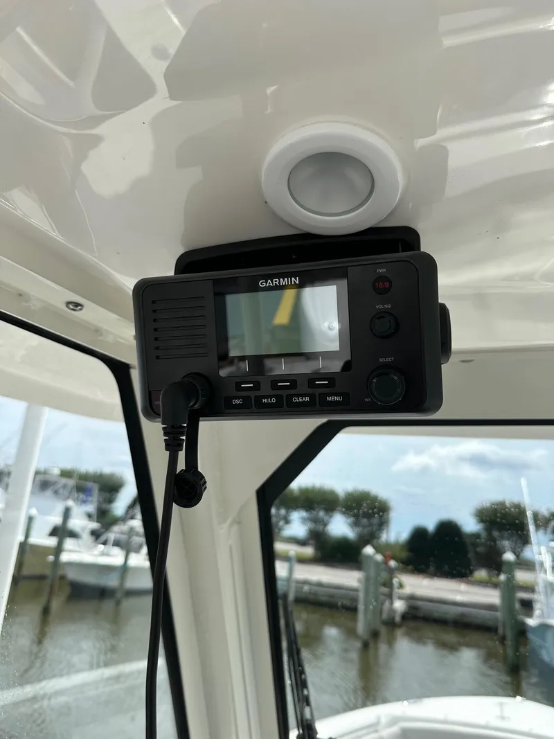 Slide: The Image of Garmin device inside 2023 Pursuit S 288 Sport boat, docked at marina. - 30