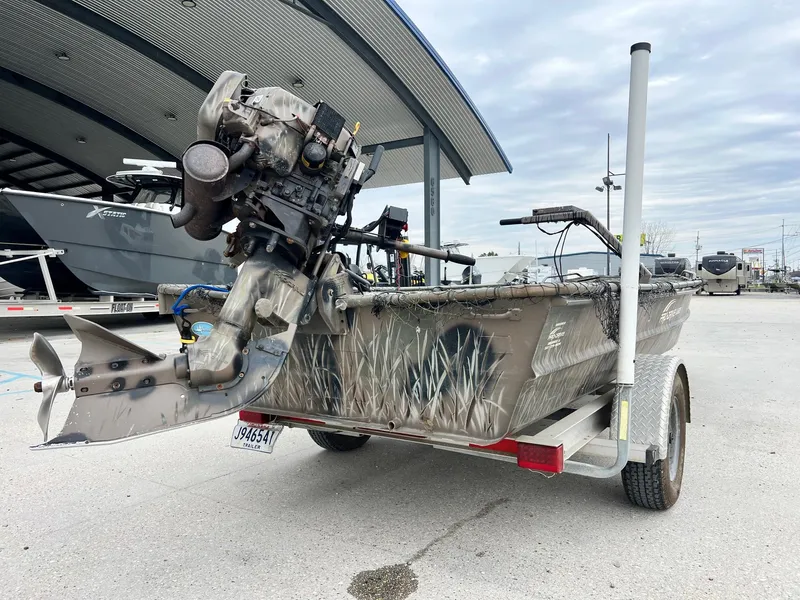 Slide: The Image of 2012 Pro-Drive 1854 boat with camouflage design on a trailer, parked outdoors. - 2