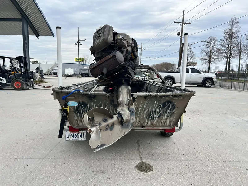 Slide: The Image of 2012 Pro-Drive 1854 boat with camo design and powerful outboard motor in a parking lot. - 3