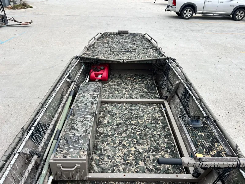 Slide: The Image of 2012 Pro-Drive 1854 boat with camouflage interior, parked on concrete surface. - 6