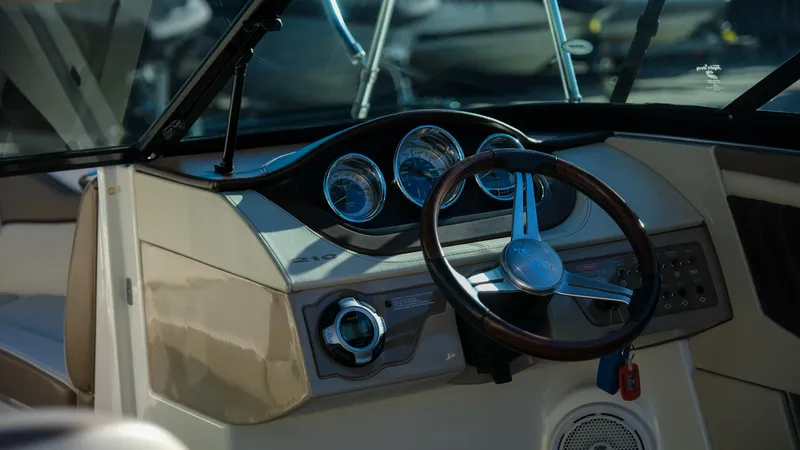 Slide: The Image of Dashboard of a 2013 Sea Ray 210 SLX boat with steering wheel and gauges. - 10