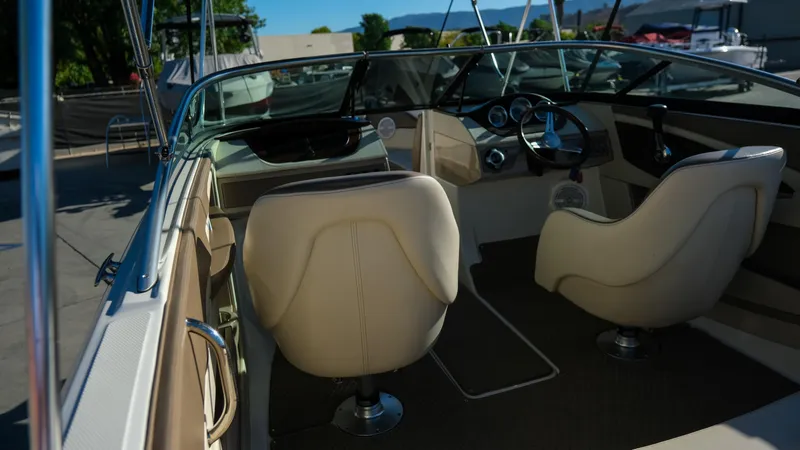 Slide: The Image of Interior of a 2013 Sea Ray 210 SLX boat with beige seating and steering wheel. - 11