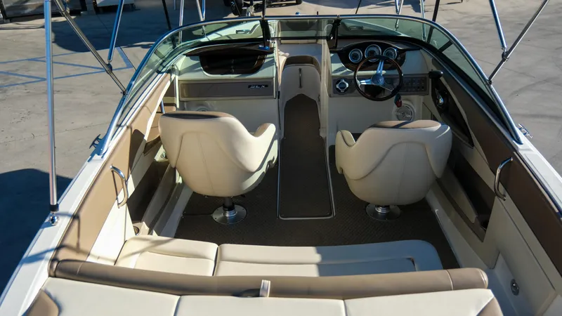 Slide: The Image of 2013 Sea Ray 210 SLX boat interior with beige seating and dashboard. - 12