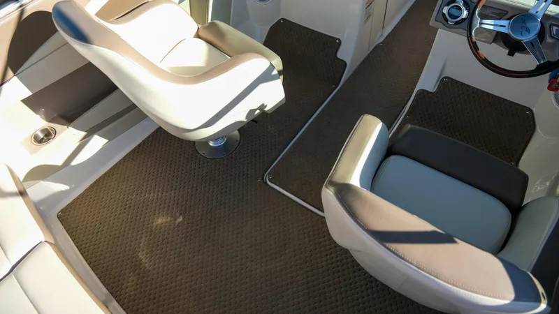 Slide: The Image of 2013 Sea Ray 210 SLX interior with beige seating and carpeted flooring. - 13