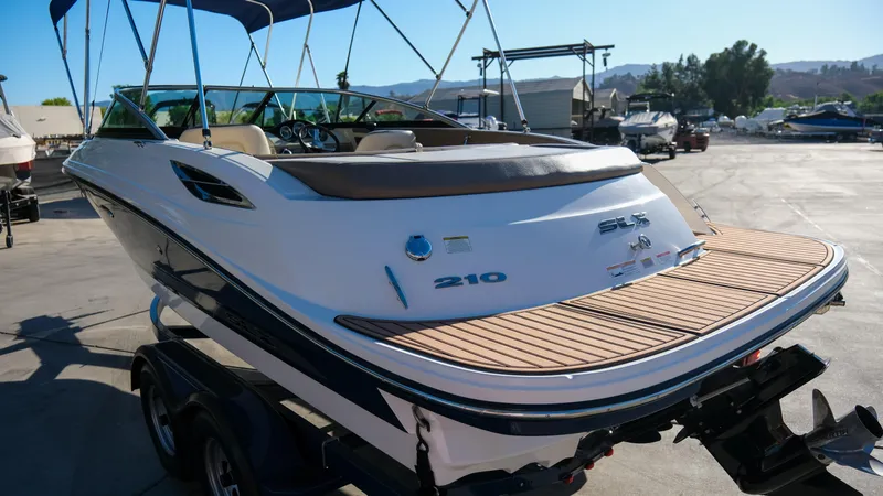 Slide: The Image of 2013 Sea Ray 210 SLX boat on trailer, featuring sleek design and spacious deck. - 4