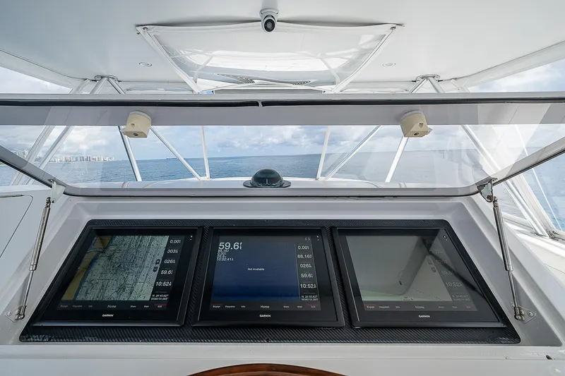 Slide: The Image of 2003 Viking Convertible yacht dashboard with navigation screens, ocean view in background. - 12