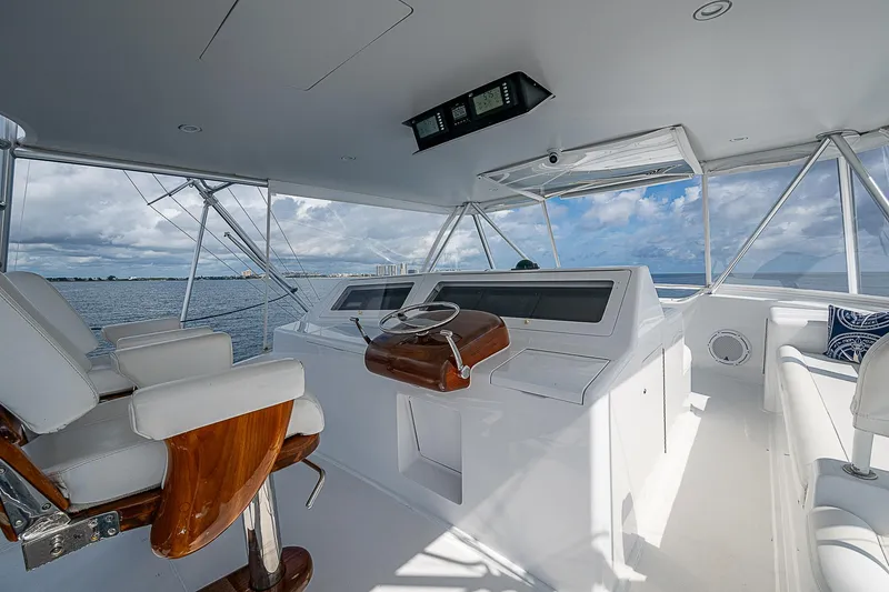 Slide: The Image of 2003 Viking Convertible yacht helm with ocean view, featuring white seating and modern controls. - 13