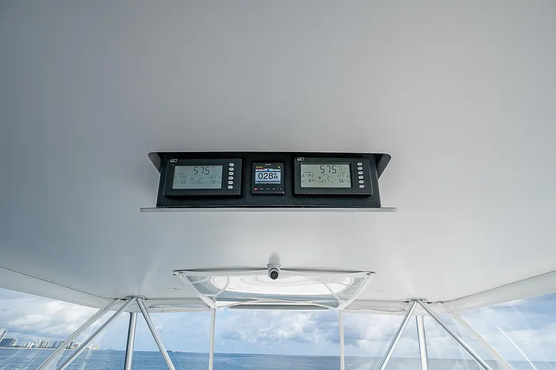 Slide: The Image of 2003 Viking Convertible boat dashboard with digital displays, ocean view in background. - 16