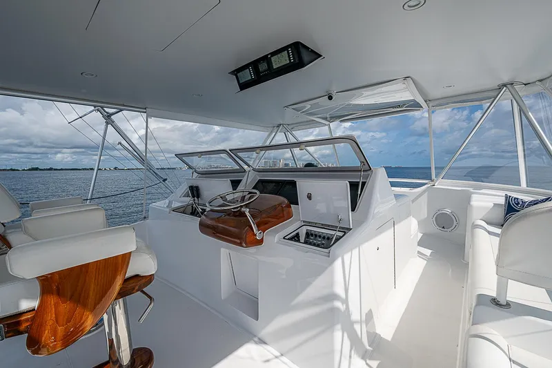 Slide: The Image of Interior of 2003 Viking Convertible yacht with helm, white seating, and ocean view. - 17