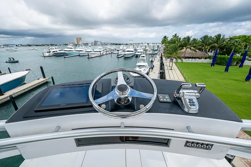 Slide: The Image of 2003 Viking Convertible yacht helm overlooking marina with boats and palm trees. - 22