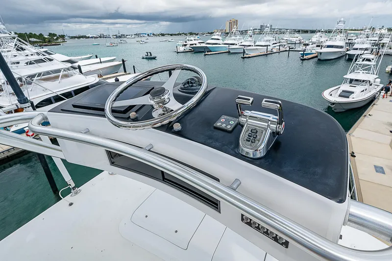 Slide: The Image of 2003 Viking Convertible yacht helm overlooking marina with multiple boats docked. - 23