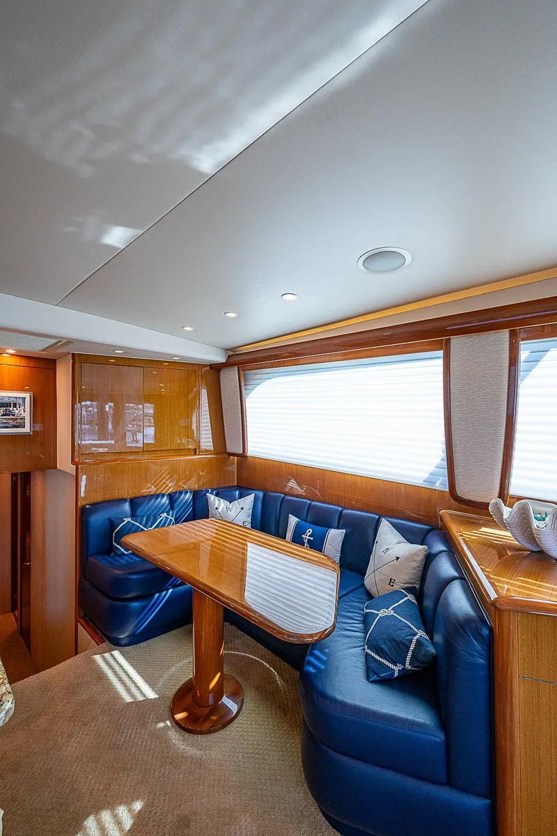 Slide: The Image of Luxurious interior of a 2003 Viking Convertible yacht with blue seating and wooden table. - 30