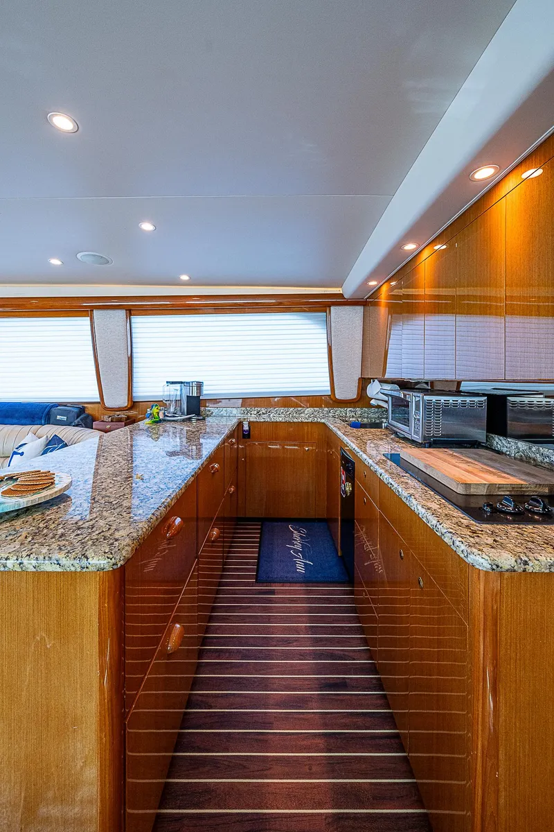 Slide: The Image of Luxurious kitchen interior of a 2003 Viking Convertible yacht with granite countertops and wood cabinetry. - 32