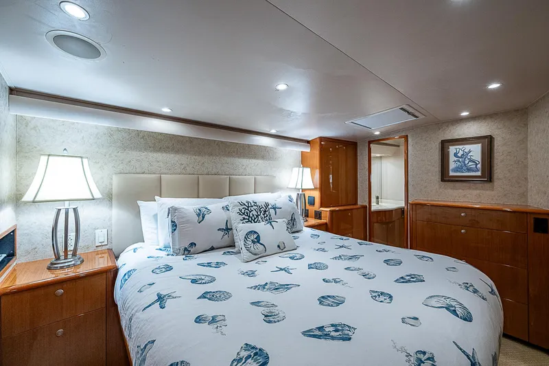 Slide: The Image of Luxurious bedroom interior in a 2003 Viking Convertible yacht, featuring nautical-themed bedding. - 36