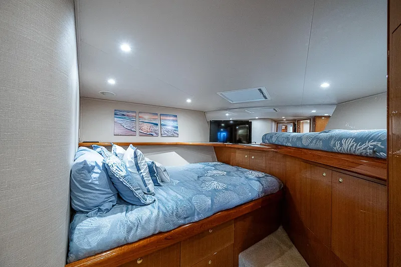 Slide: The Image of Luxurious cabin interior of a 2003 Viking Convertible yacht with cozy bedding and elegant decor. - 39