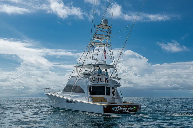 Slide: The Image of 2003 Viking Convertible yacht cruising on open sea under a clear blue sky. - 4