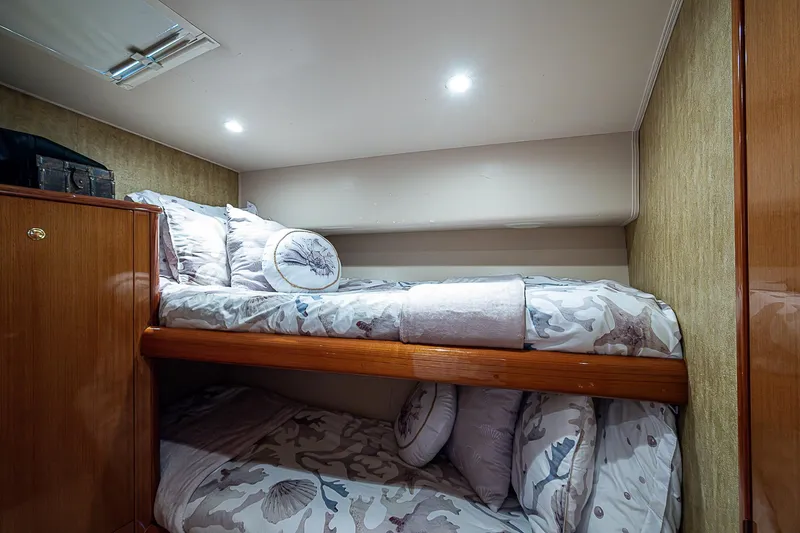 Slide: The Image of Bunk beds in a 2003 Viking Convertible yacht cabin with patterned bedding and soft lighting. - 41