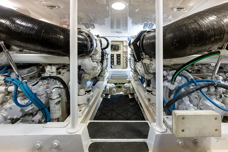 Slide: The Image of Engine room of a 2003 Viking Convertible yacht, showcasing dual engines and piping. - 43