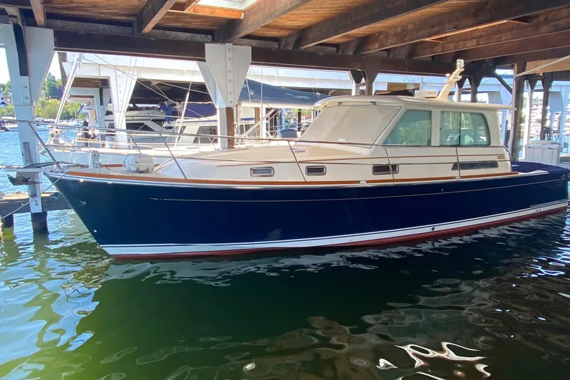 Slide: The Image of 2011 Sabre 42 Salon Express yacht docked under a wooden shelter. - 0