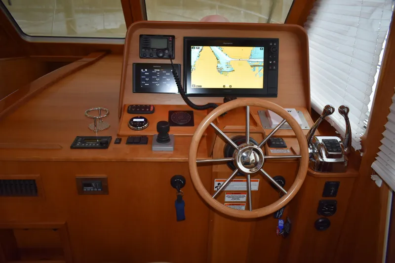 Slide: The Image of 2011 Sabre 42 Salon Express helm with navigation display and wooden steering wheel. - 19