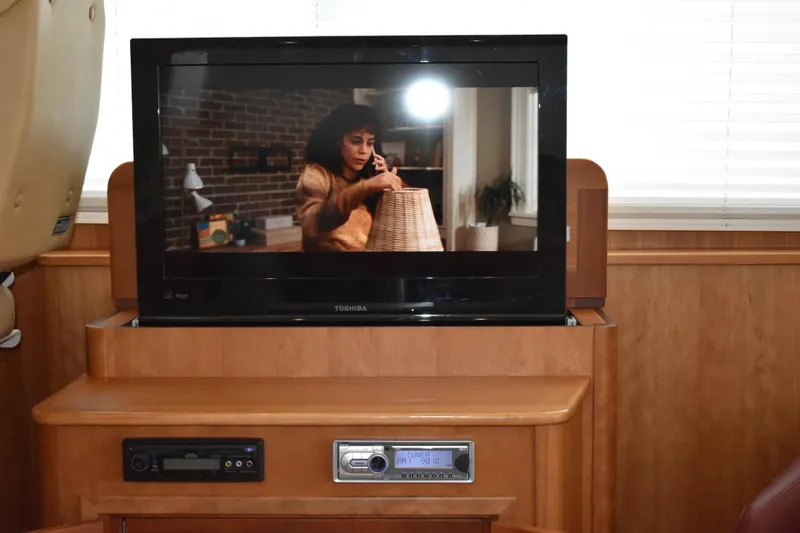 Slide: The Image of Entertainment system inside 2011 Sabre 42 Salon Express yacht, featuring a TV and audio controls. - 27