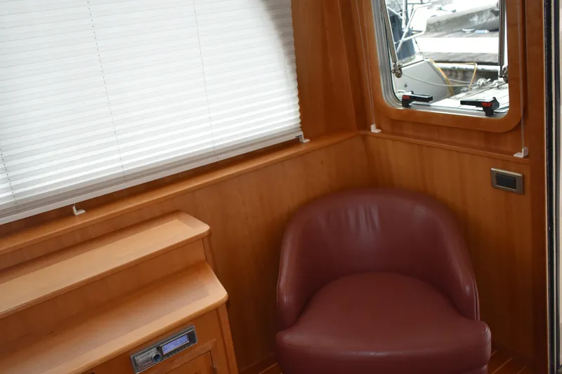 Slide: The Image of Interior of 2011 Sabre 42 Salon Express with tub chair and wooden paneling. - 30
