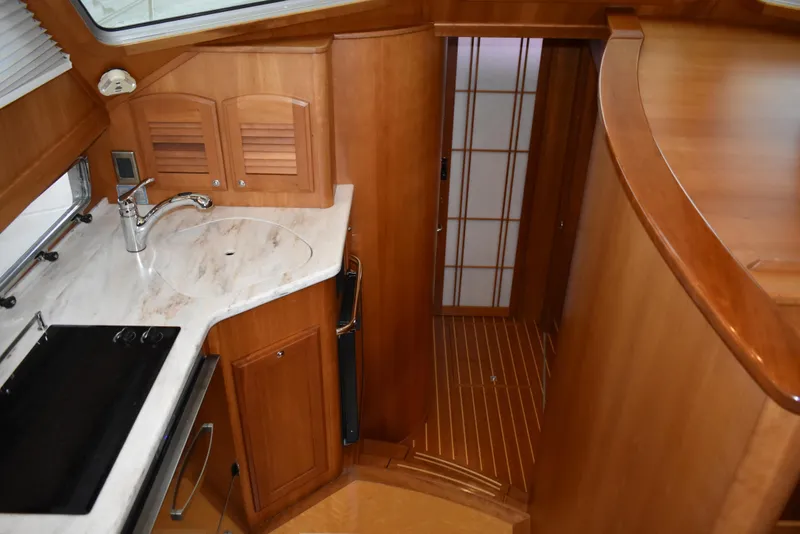 Slide: The Image of 2011 Sabre 42 Salon Express interior with wooden cabinetry and compact kitchen area. - 41