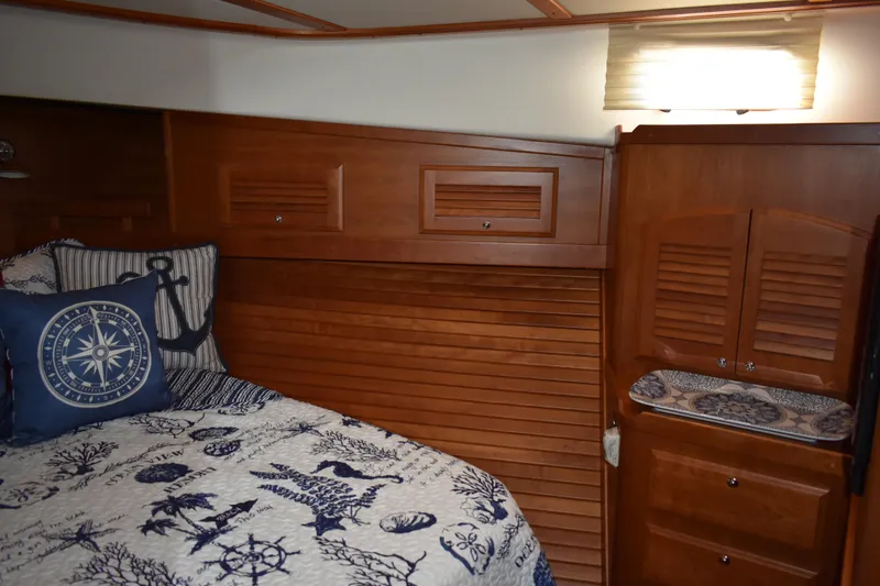 Slide: The Image of 2011 Sabre 42 Salon Express cabin with nautical-themed bedding and wooden cabinetry. - 46
