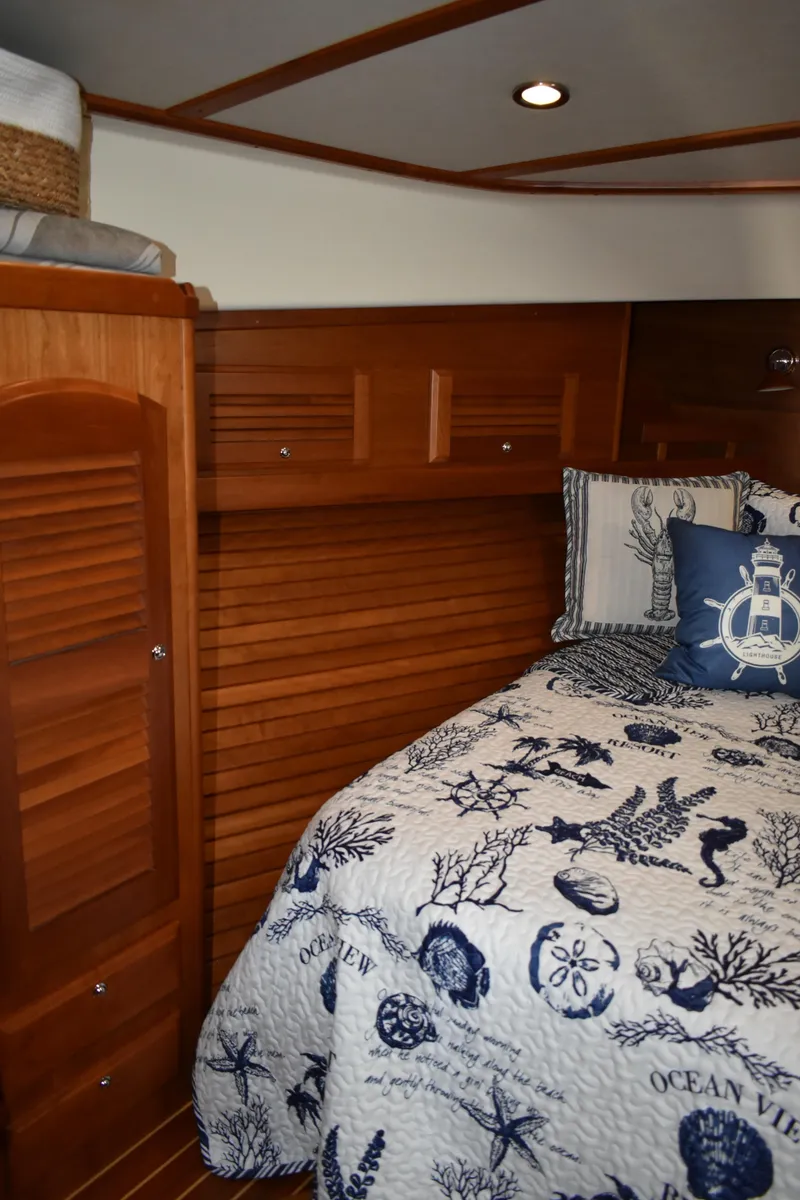 Slide: The Image of 2011 Sabre 42 Salon Express cabin with nautical-themed bedding and wooden interior. - 47