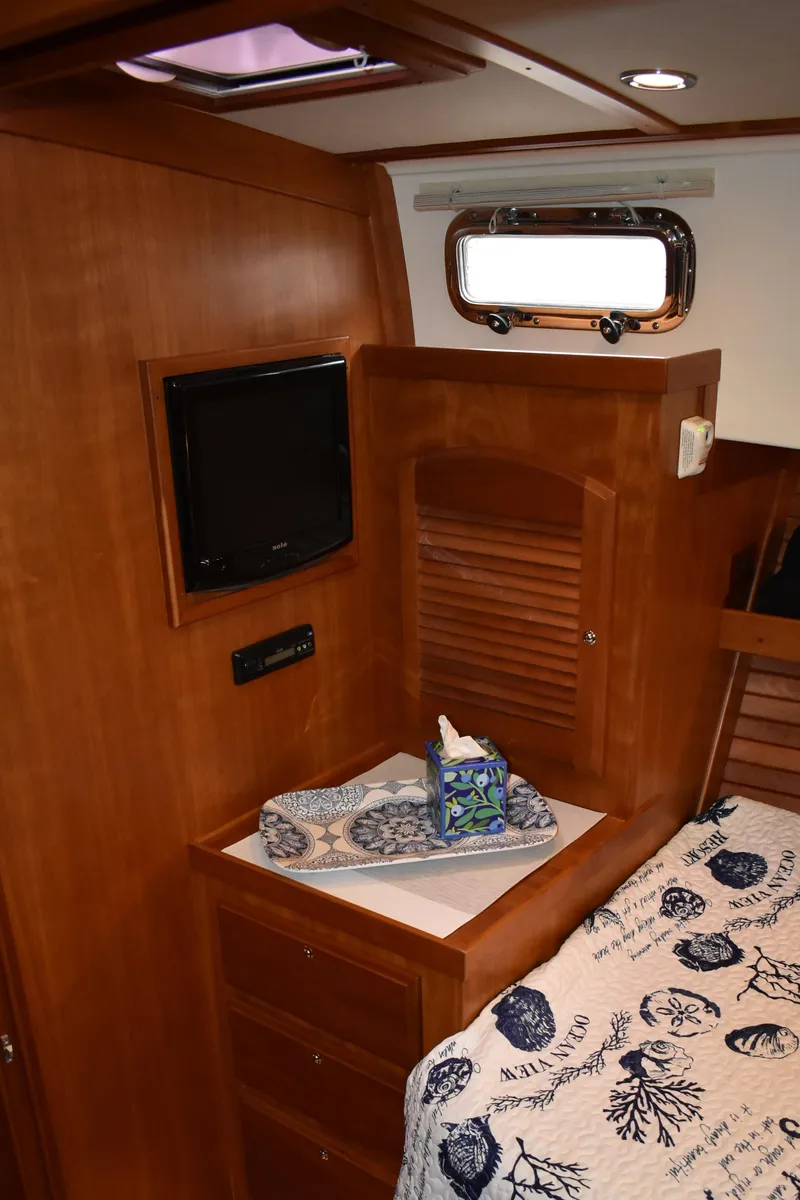 Slide: The Image of 2011 Sabre 42 Salon Express cabin interior with wood finish and cozy bedding. - 49