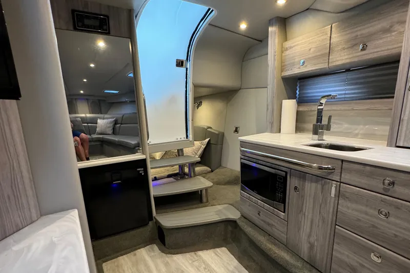 Slide: The Image of Interior of a 2020 Formula 370 SS boat, featuring modern kitchen and seating area. - 34