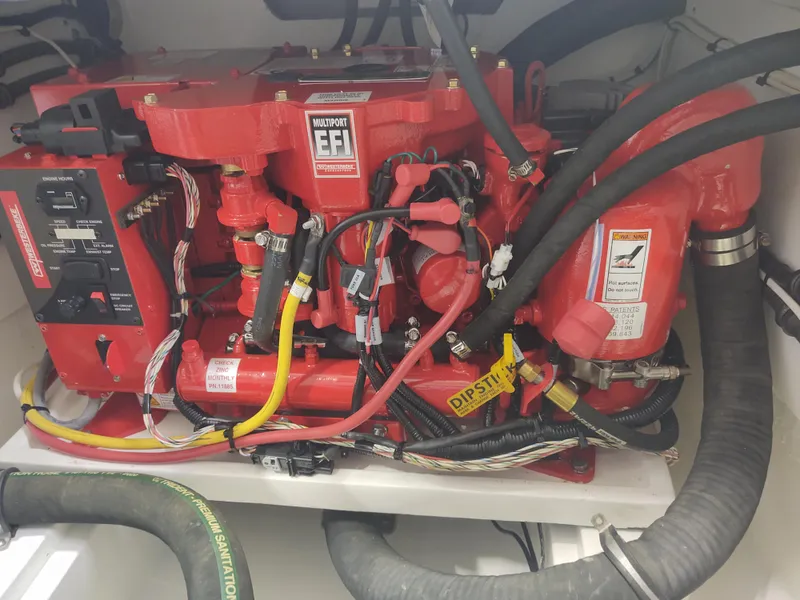 Slide: The Image of Engine compartment of a 2022 MJM 3 boat, featuring red EFI components and various hoses. - 32