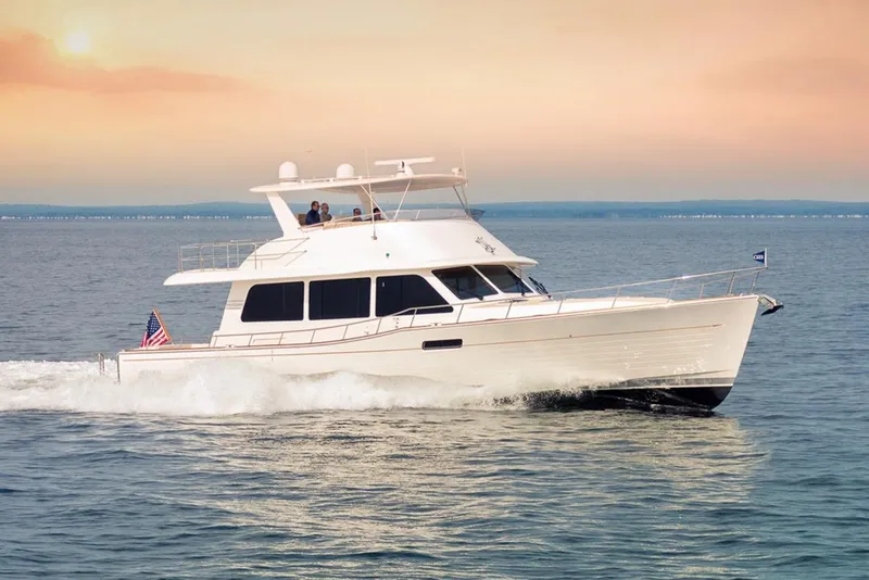 Slide: The Image of 2026 Grand Banks GB 60 yacht cruising on open water at sunset. - 1