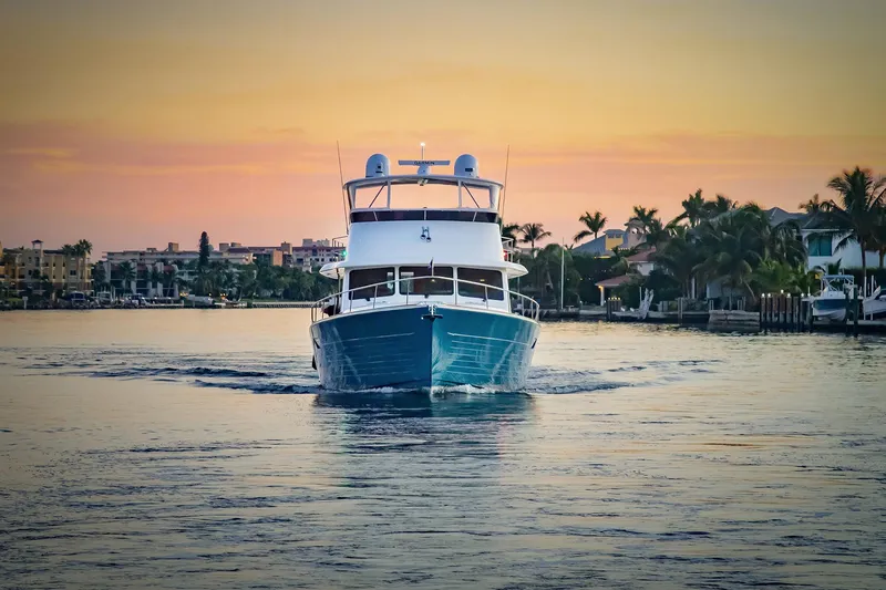 Slide: The Image of Grand Banks GB 60 yacht cruising at sunset, 2026 model, serene waterfront view. - 26