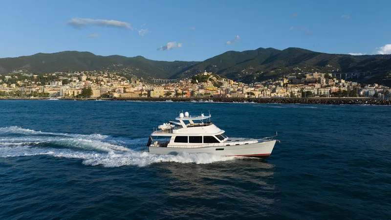 Slide: The Image of 2026 Grand Banks GB 60 yacht cruising on blue waters with scenic coastal backdrop. - 29