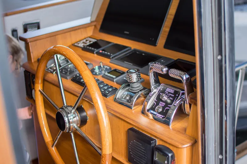 Slide: The Image of Helm of 2026 Grand Banks GB 60 yacht with wooden steering wheel and modern controls. - 17