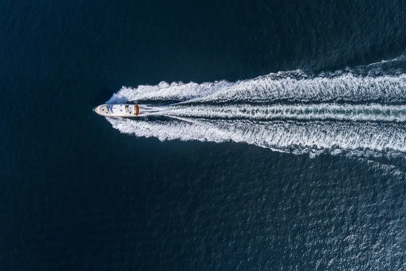Slide: The Image of Aerial view of 2026 Grand Banks GB 54 yacht cruising on open water. - 14