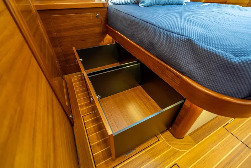 Slide: The Image of Under-bed storage drawers in 2026 Grand Banks GB 54 yacht cabin, featuring elegant wood finish. - 19