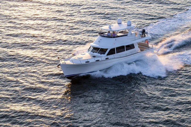 Slide: The Image of 2026 Grand Banks GB 54 yacht cruising on open water at sunset. - 30