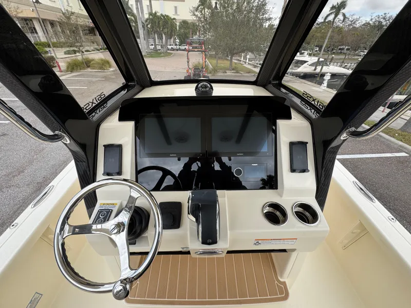 Slide: The Image of 2025 Scout 261 XSS boat dashboard with steering wheel and dual screens. - 13