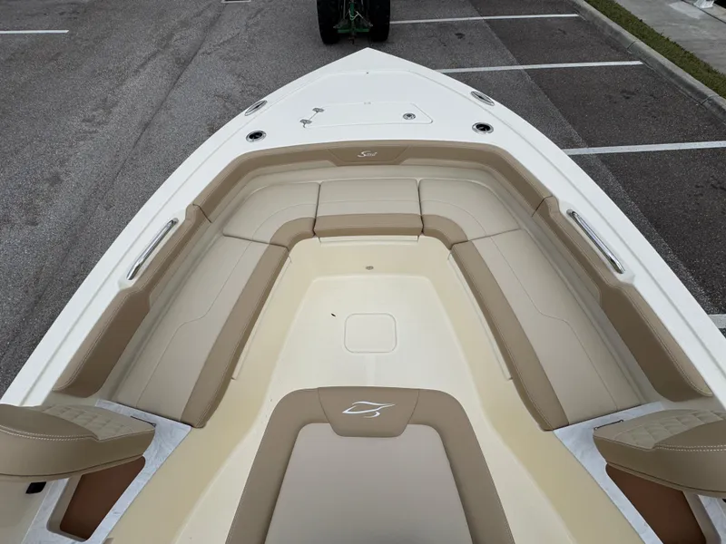 Slide: The Image of 2025 Scout 261 XSS boat interior with beige seating and spacious deck. - 17