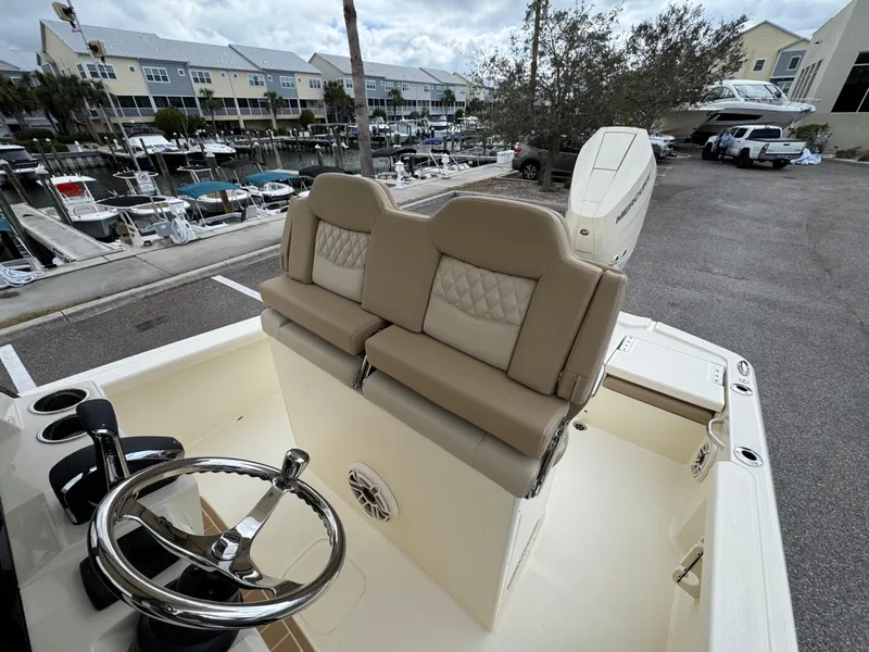 Slide: The Image of 2025 Scout 261 XSS boat interior with dual seats and steering wheel, docked at marina. - 21