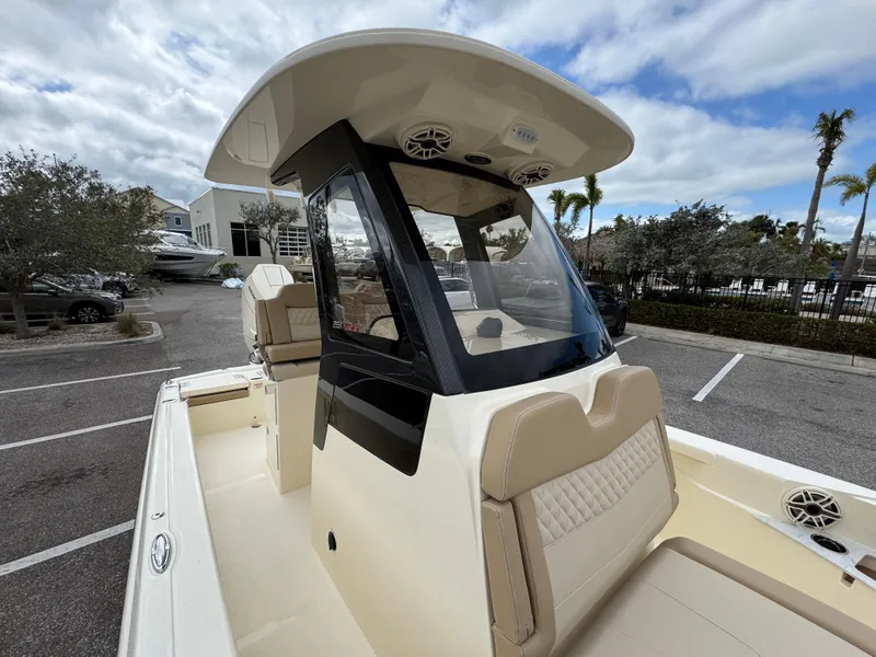 Slide: The Image of 2025 Scout 261 XSS boat with sleek design, parked outdoors under cloudy sky. - 23